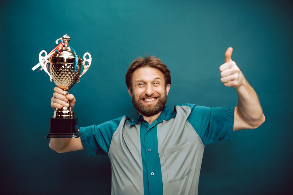 Mann mit Pokal der Gedanke Erfolgreich werden