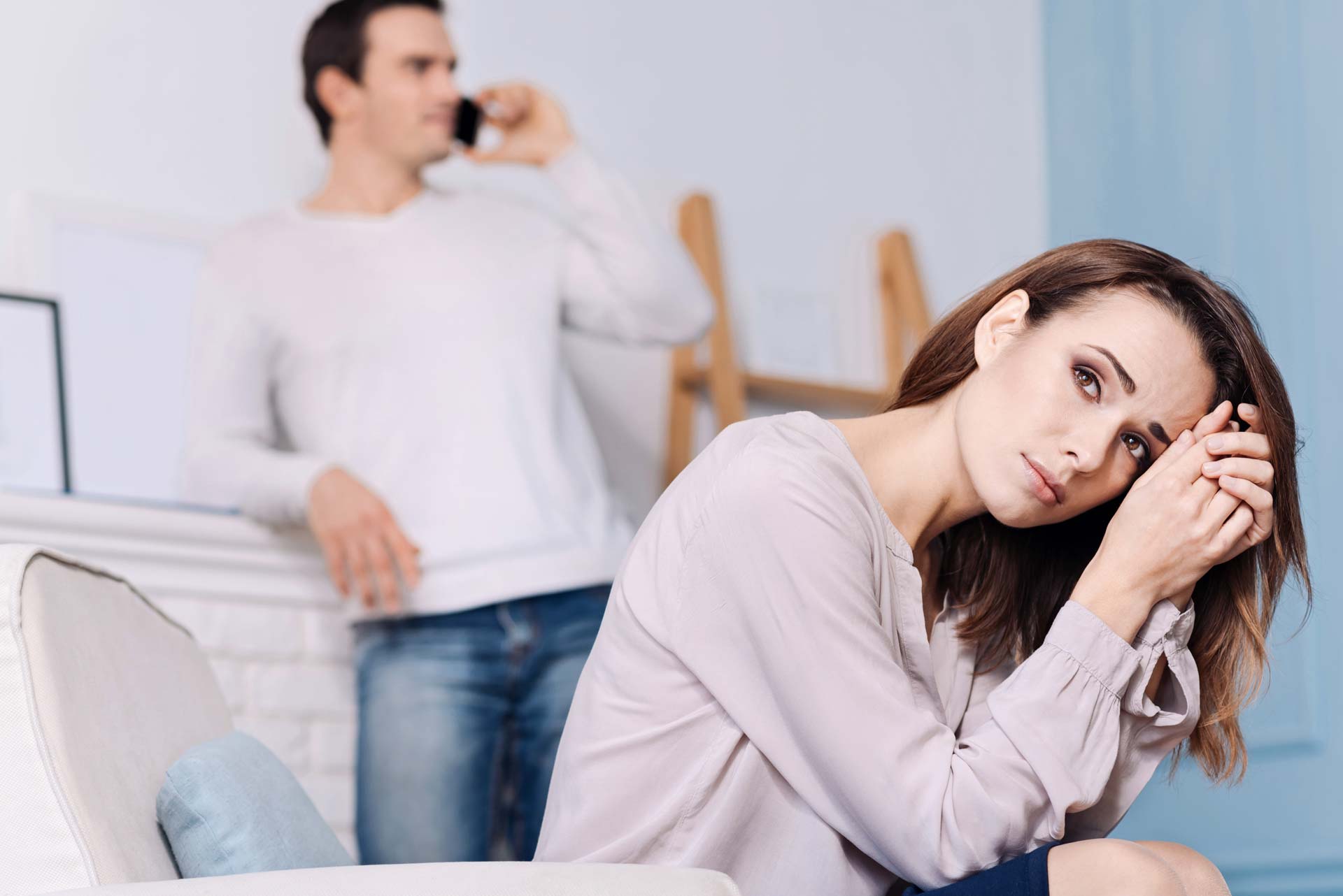 Mann telefoniert mit Schwiegermutter, die Frau ist genervt